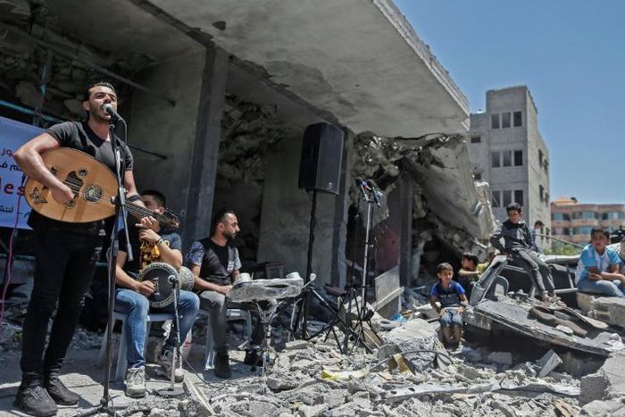 The Palestinian band Dawaween performs on May 14, 2019 on the rubble of a building in the Gaza Strip that was recently destroyed by Israeli air strikes during an event calling for a boycott of the Eurovision song contest hosted by Israel
