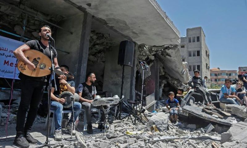 The Palestinian band Dawaween performs on May 14, 2019 on the rubble of a building in the Gaza Strip that was recently destroyed by Israeli air strikes during an event calling for a boycott of the Eurovision song contest hosted by Israel