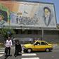 Iranians walk under a mural of Ayatollah Ruhollah Khomeini, who remains a guiding figure in the country 30 years after his death