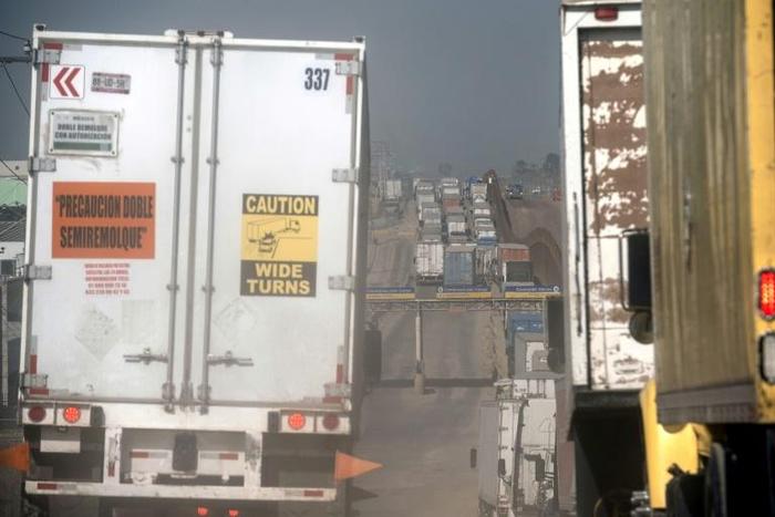 Trucks line up to cross from Mexico to the United States near the border in Tijuana