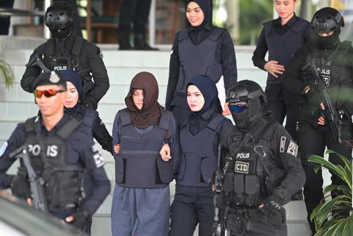 Vietnamese national Doan Thi Huong (brown headscarf) is escorted by Malaysian police after her last court appearance