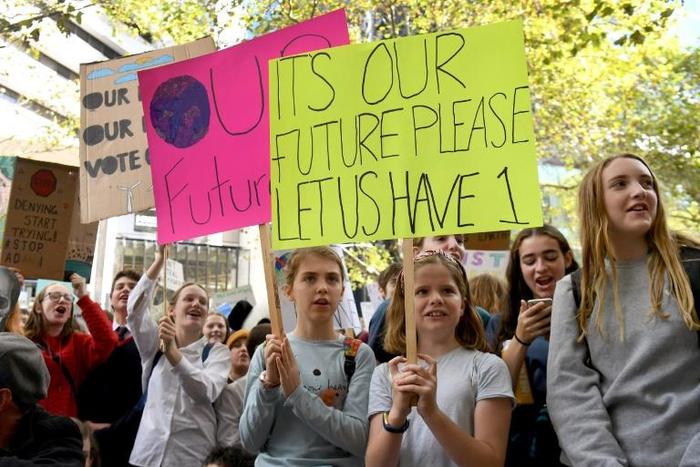 Students hold up placards during an environmental protest in Melbourne on May 3, 2019