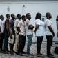 Suspects who were arrested by Nigerian Army personnel on election day in connection with various alleged electoral offenses, including stealing a carton of presidential ballot papers, stand in line to be handed over to police in Port Harcourt