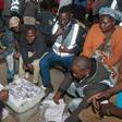 Polling staff and party monitors count votes at a polling station in in Blantyre