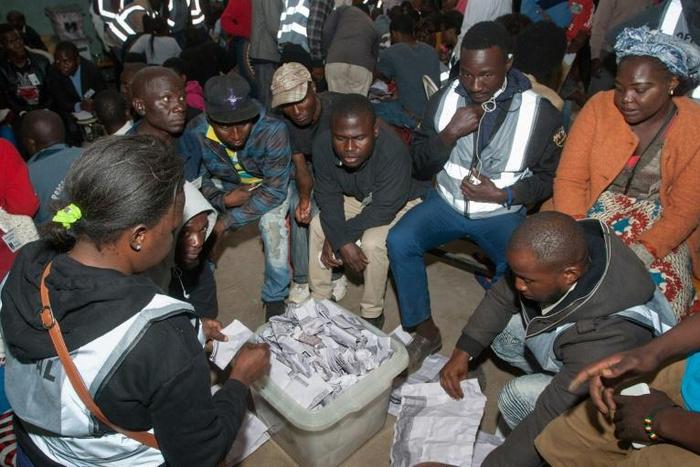 Polling staff and party monitors count votes at a polling station in in Blantyre