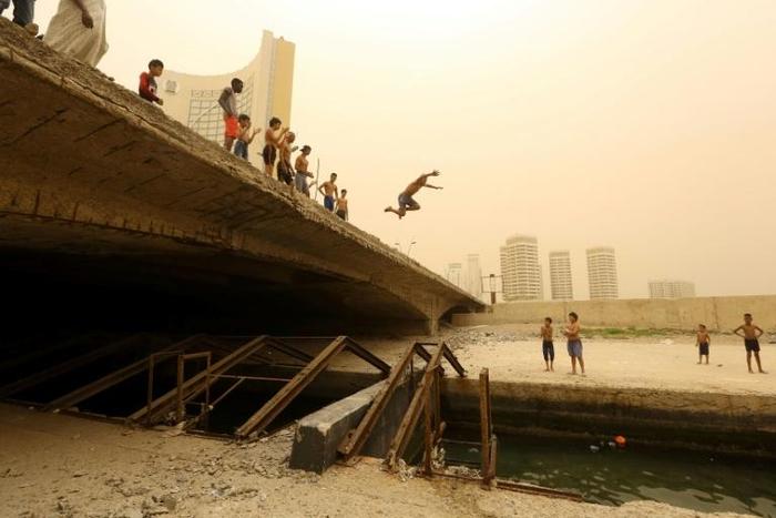 Children play near the port of Tripoli, away from the battle for control over the city
