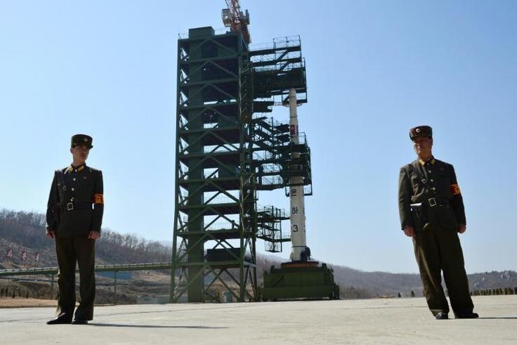 Soldiers stand guard in front of the Unha-3 rocket at North Korea's Sohae Satellite Launch Station, in 2012