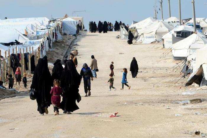 Foreign women and children walk inside the Al Hol camp housing relatives of Islamic State group members in northeastern Syria in March 2019