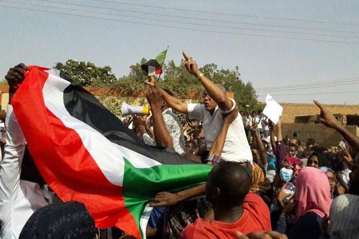 Sudanese protesters wave their national flag and chant slogans during an anti-government demonstration in the capital Khartoum's twin city of Omdurman on January 31