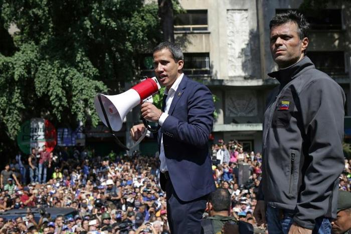 Venezuela's top court has ordered the arrest of Leopoldo Lopez, seen here April 30 with opposition leader Juan Guaido (C), for violating the terms of his house arrest