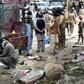 Pakistani security officials inspect the site of a bomb blast at a fruit market in Quetta