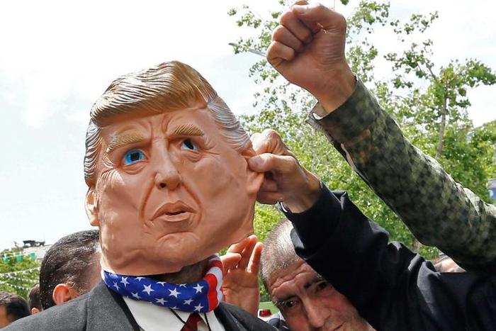 Iranians protest using a mask depicting US President Donald Trump during a rally in Tehran on May 19, 2019