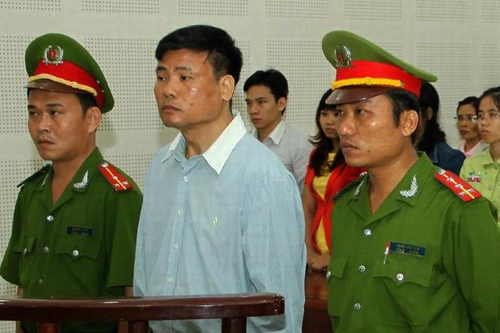 Blogger Truong Duy Nhat stands trial in the Vietnamese city of Danang in March 2014 after criticizing the communist leadership (C) stands trial at a local People's Court in the central city of Da Nang on March 4, 2014. Popular Vietnamese blogger and jo...