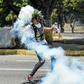 An anti-government protester throws Molotov cocktails during clashes with security forces near the La Carlota military base in Caracas