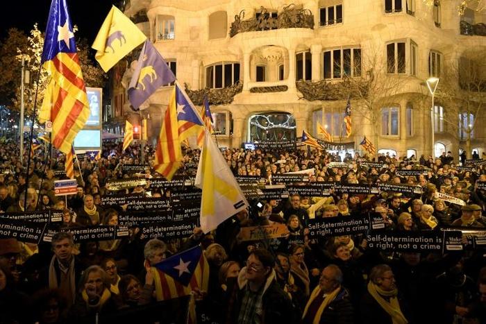 People hold placards reading "Self determination is a right, not a crime" in Barcelona on February 1, during a demonstration in support of jailed Catalan pro-independence leaders