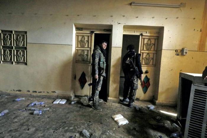 A fighter from the Syrian Democratic Forces (SDF) walks inside a former Islamic State (IS) group prison in the city of Hajin, the last remaining IS pocket in Syria