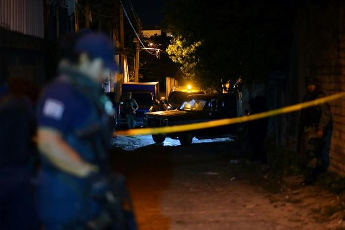 Police stand guard outside the setting of a party where 13 people were killed by unidentified gunmen