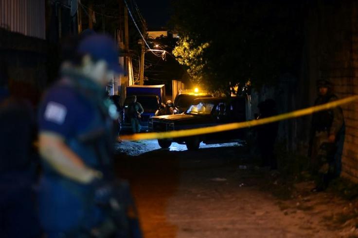 Police stand guard outside the setting of a party where 13 people were killed by unidentified gunmen