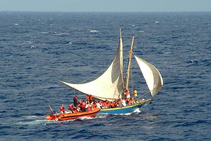 This image released 27 February 2004 by the US Coast guard shows an overloaded Haitian migrant vessel (R) being located by the US Coast Guard (L) in the Windward Pass, between Haiti and eastern Cuba