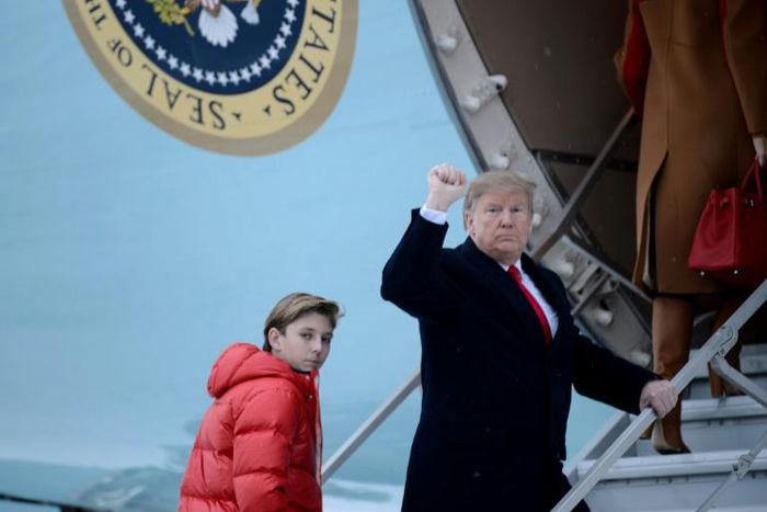 US President Donald Trump says he would not encouragae his son Barron, seen here boarding Air Force One with his father, to play American football