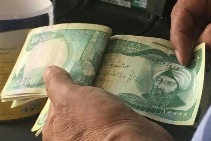 The United States is sanctioning seven financiers who allegedly helped funnel money to the Islamic State group -- seen here are 10,000-dinar banknotes in Iraq