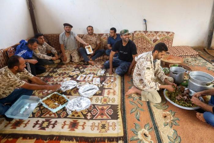 Fighters loyal to Libya's internationally-recognised Government of National Accord (GNA) prepare an Iftar meal south of Tripoli