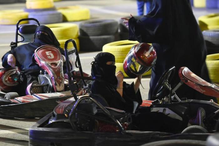 Saudi women attend an electronic driving simulator during a go-cart driving workshop for women in the capital Riyadh
