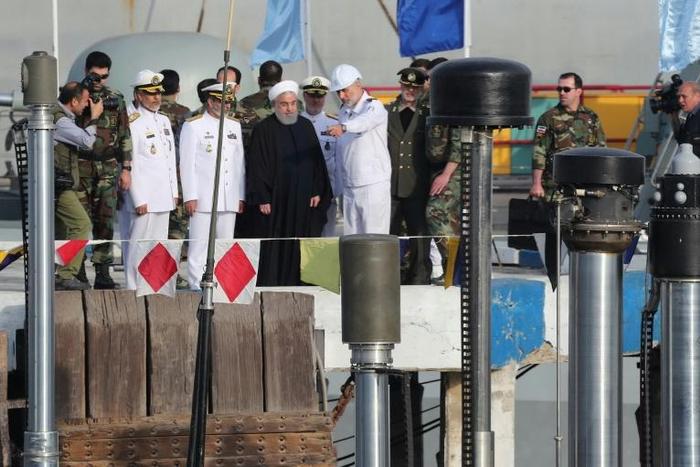 A handout picture provided by Iran's presidency on February 17, 2019, shows Hassan Rouhani (dressed in black) during the unveiling of the country's first semi-heavy submarine at Bandar Abbas naval base