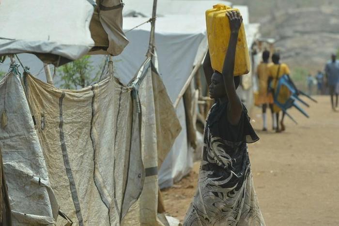 A woman carries a container of water at a UN-protected site in Juba that offers shelter to civilians fleeing fighting