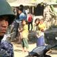 A Myanmar border guard stands near a group of Rohingya Muslims in front of their homes in restive Rakhine state. The military has poured thousands of troops into the area to put down an insurgency