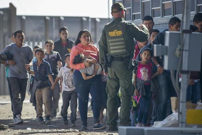Migrants are loaded onto a bus by US Border Patrol agents after being detained when they crossed into the United States from Mexico on June 01, in El Paso, Texas