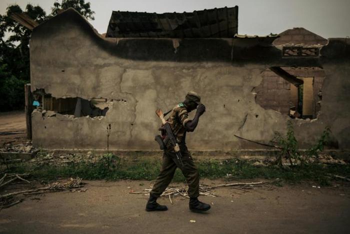 A soldier walks past a burnt building in Yumbi, where the December 16-17 massacre claimed 535 lives, according to a UN toll