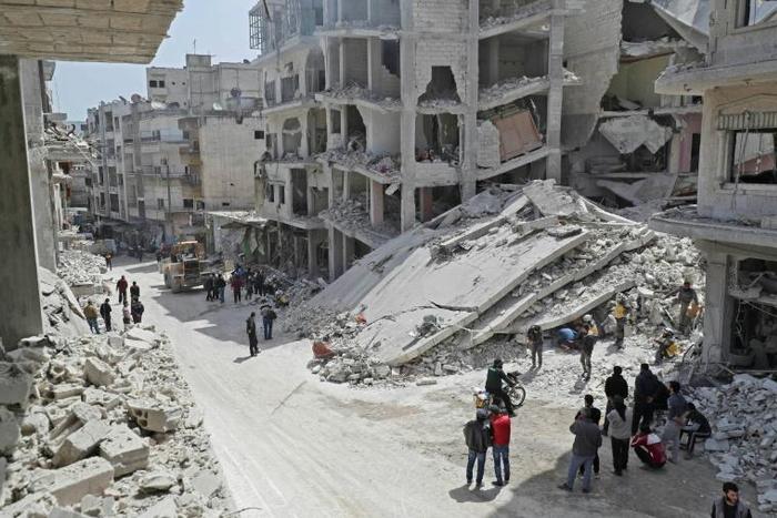 Members of the Syrian Civil Defence, also known as the "White Helmets", search the rubble of a collapsed building following an explosion in the town of Jisr al-Shughur, in the mostly rebel-held Syrian province of Idlib, on April 24, 2019