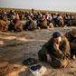 Suspected Islamic State group fighters wait to be searched after leaving the jihadists' last holdout in eastern Syria
