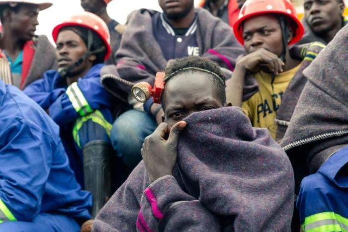 Miners watch rescue operations at a flooded gold mine near Kadoma in February where more than two dozen illegal diggers were drowned