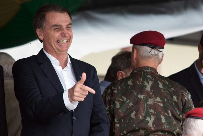 Brazil's President-elect Jair Bolsonaro (L), pictured at a graduation ceremony November 24, 2018, is embroiled in a crisis over campaign financing