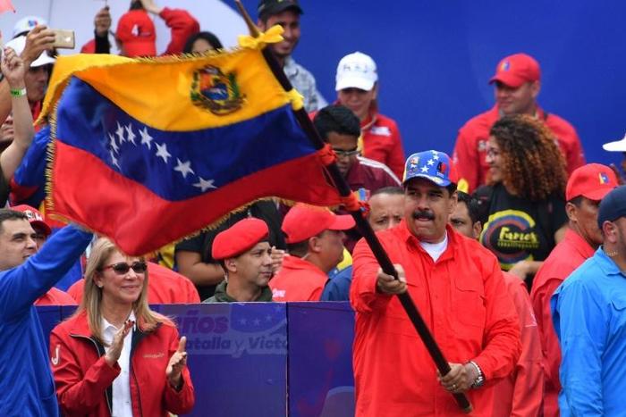 President Nicolas Maduro waves a Venezuelan flag at a rally to mark the 20th anniversary of the rise of power of the late Hugo Chavez