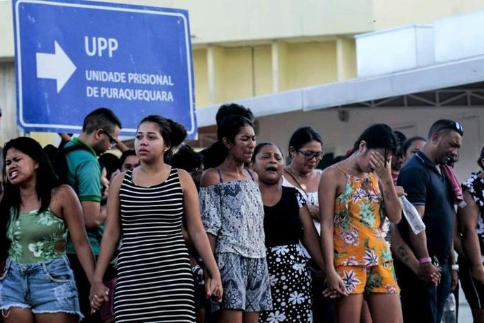 Familiares de presos en el penal de Puraquequara, en Manaos, Brasil, rezan frente a la cárcel