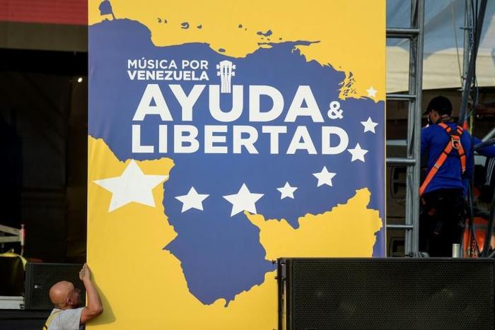 Workers set up posters for a charity concert for the Venezuelan opposition
