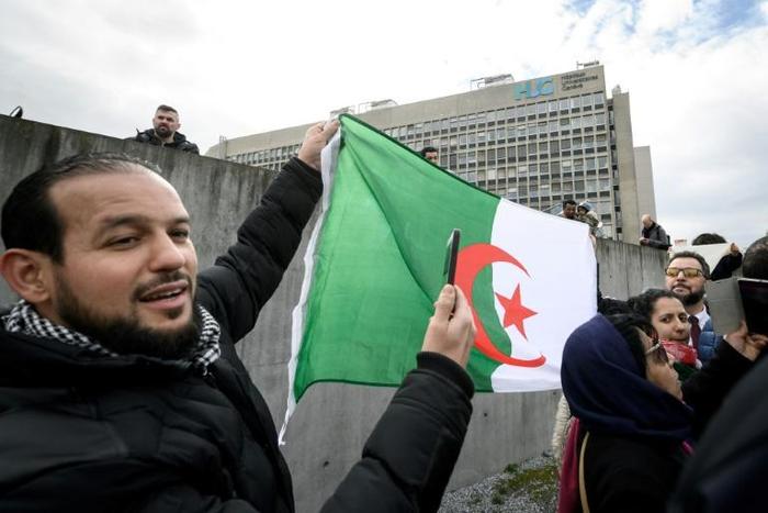A man holds an Algerian flag in front of the Geneva University Hospitals (HUG) in Geneva where ailing President Abdelaziz Bouteflika is receiving treatment