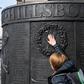 People touch the Hillsborough Memorial Monument as Liverpool observes a minute's silence on the 30th anniversary of the stadium disaster that took the lives of 96 Reds fans