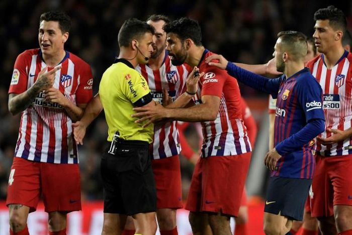 Atletico Madrid's Spanish forward Diego Costa confronts referee Gil Manzano during the Spanish league match against Barcelona