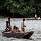 Venezuelans take boats from one muddy shore to the other to buy supplies from Colombia or journey onwards