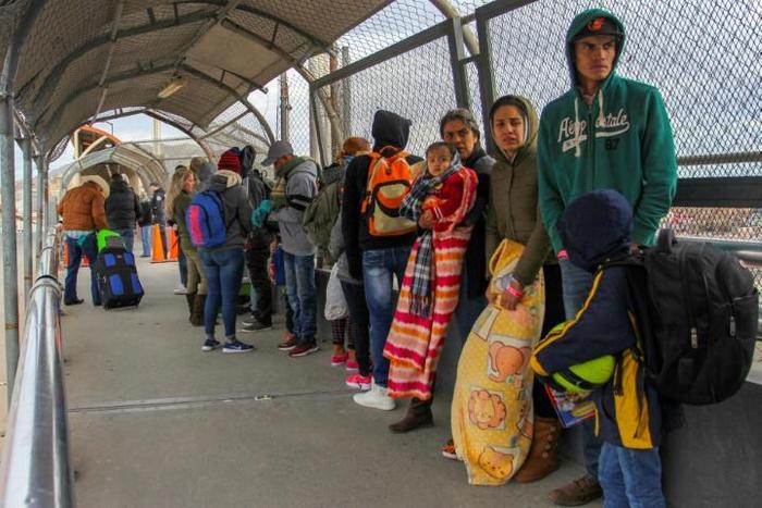 In this file photo taken on January 9, 2019 migrants from Cuba, Venezuela and Central America queue at the Paso del Norte International Bridge in Ciudad Juarez, Mexico, to cross the border and request political asylum in the United States