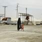 A woman and child walk through the Al-Hawl refugee camp in northeast Syria, where families with Australia-based relatives are being held