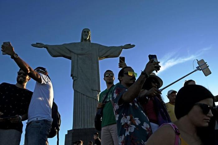 Tourists take selfies by the Christ the Redeemer statue in Rio de Janeiro -- one of many must-have selfie spots in the Brazilian city