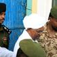 Ousted Sudanese leader Omar al-Bashir who appeared in court Monday for the start of his trial on corruption charges is seen in this June 2019 picture being escorted from the Kober prison to the prosecutor's office in North Khartoum