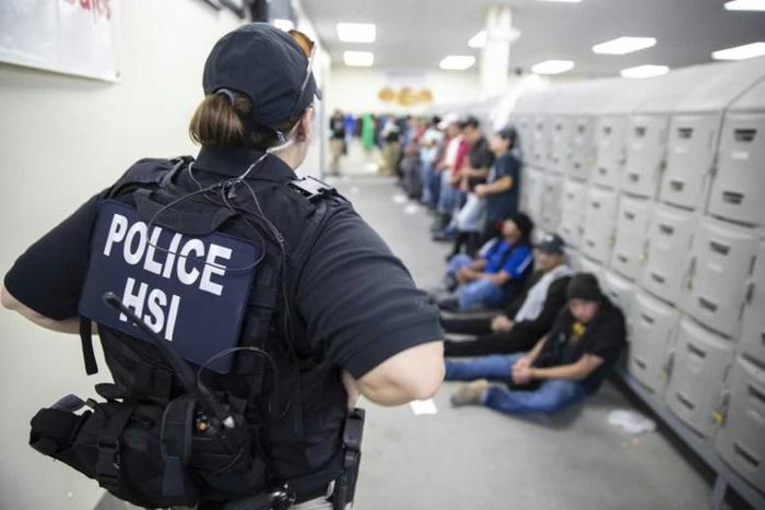 A Homeland Security officer guards some of the 680 suspected undocumented migrants detained in Mississippi after Immigration and Customs Enforcement officers raided several slaughterhouses