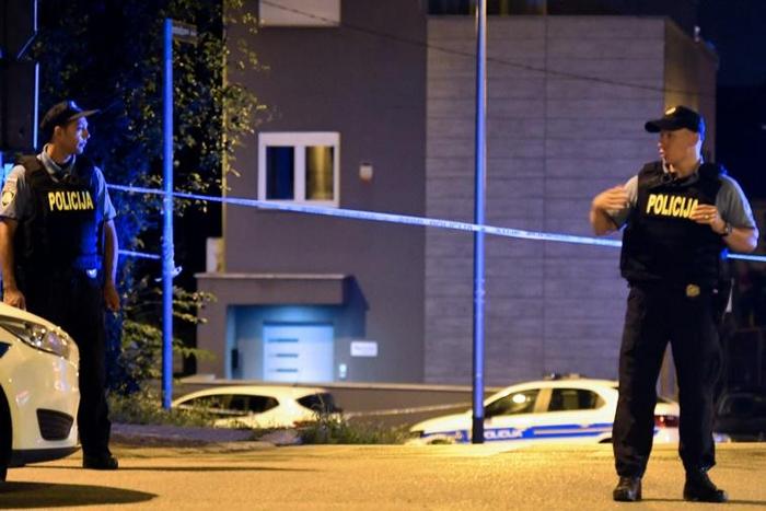 Police officers stand guard at a check point after six people were shot dead nearby in Zagreb, Croatia on August 1