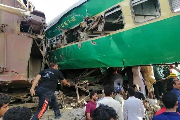 Rescuers and onlookers gather around the twisted wreckage of train carriages after the accident